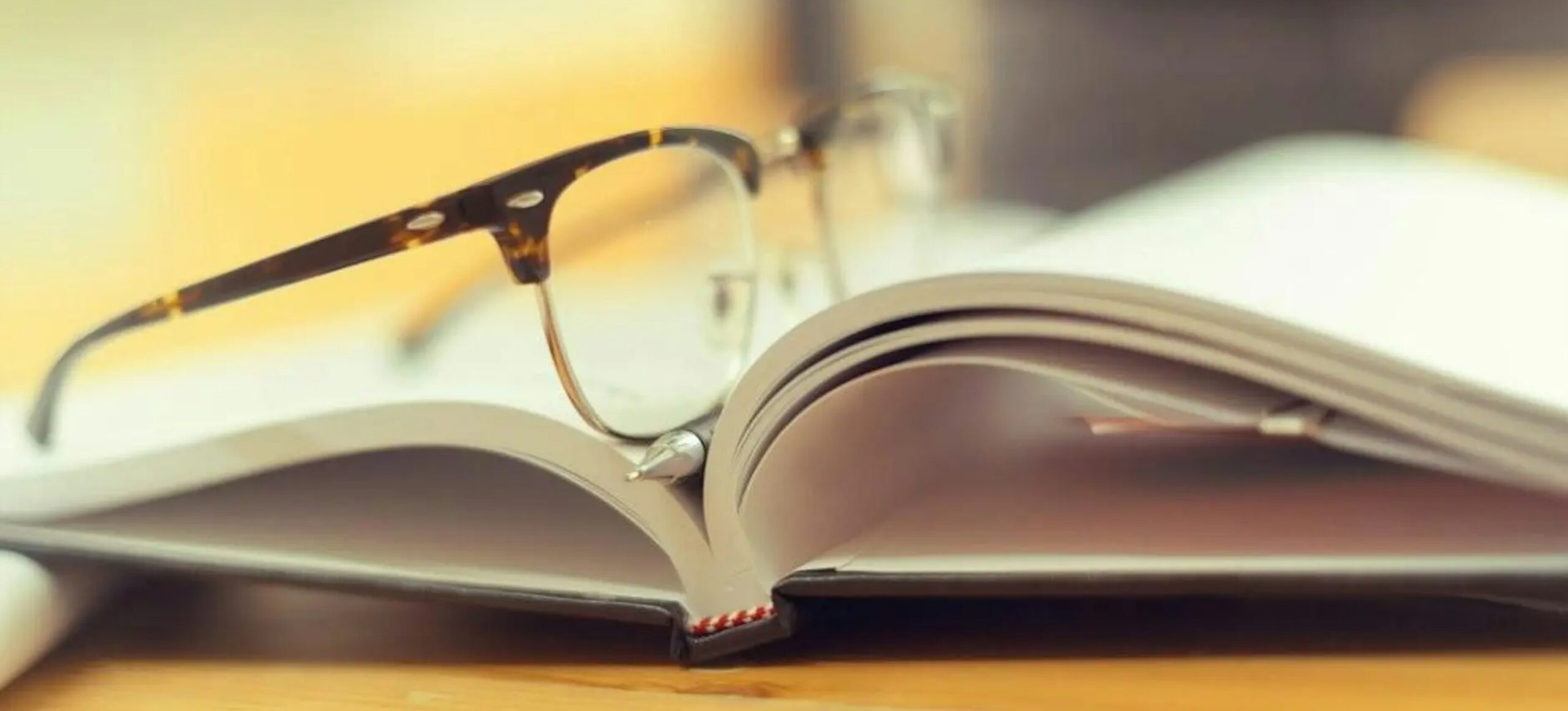 photo of glasses resting on a book