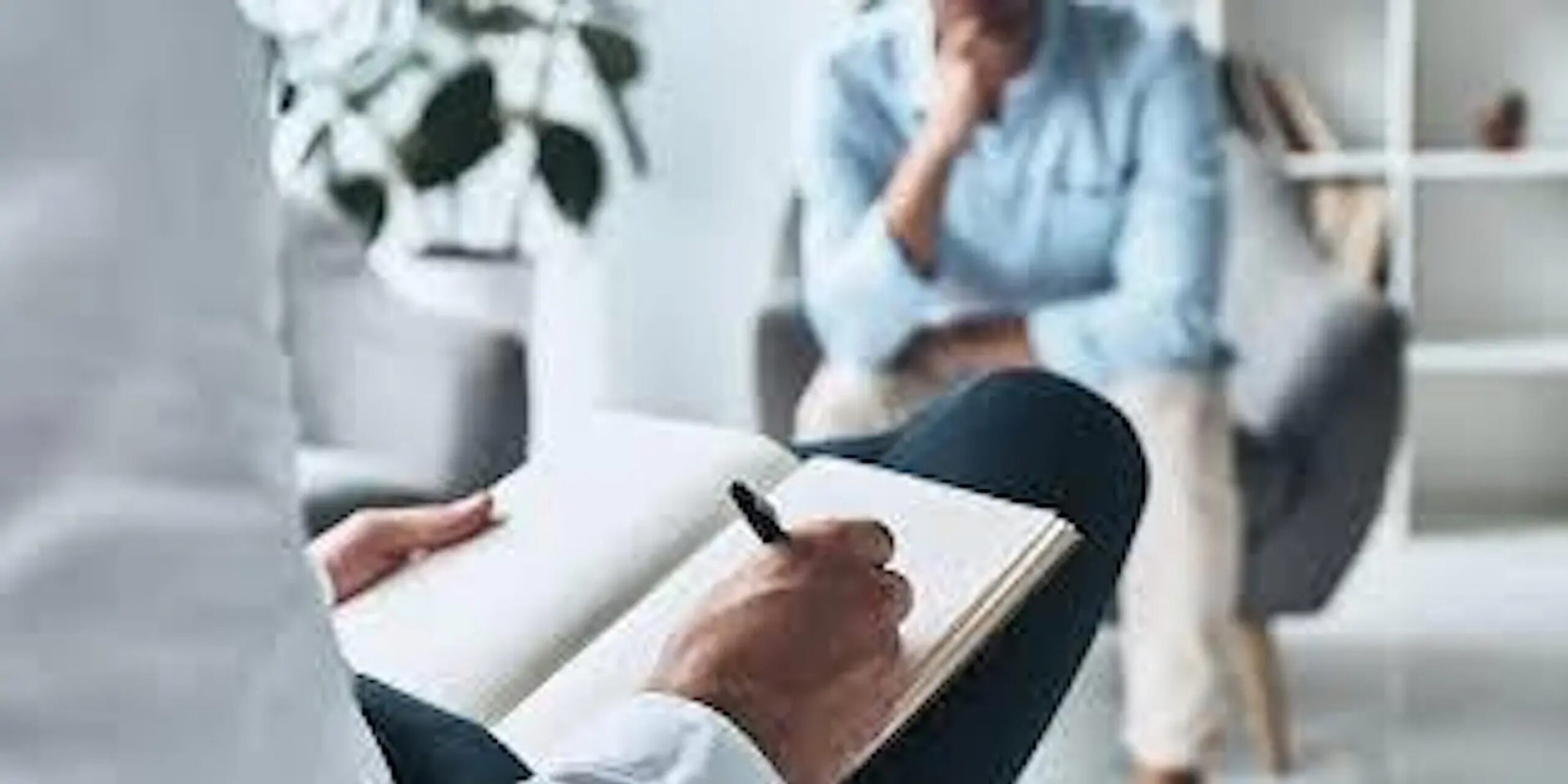 Photo of a person taking notes in a meeting