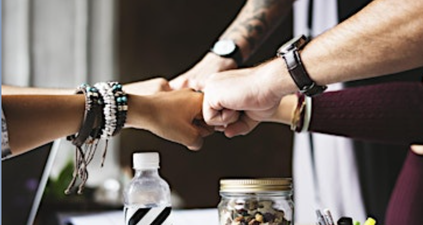 A group of people toughing fists together